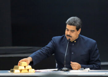 Foto de archivo del presidente de Venezuela, Nicolás Maduro, tocando una barra de oro durante una reunión con ministros del área económica en Caracas. 22 de marzo de 2018. REUTERS/Marco Bello.