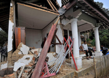 Locals sit at thier house damaged after an earthquake hit in Pandeglang, Banten province, Indonesia, August 3, 2019. Antara Foto/Asep Fathulrahman/ via REUTERS  ATTENTION EDITORS - THIS IMAGE WAS PROVIDED BY A THIRD PARTY. MANDATORY CREDIT. INDONESIA OUT