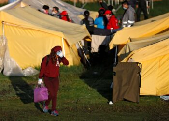 A Venezuelan migrant girl carries her belongings out of a tent inside a temporary humanitarian camp that is closed by the government, in Bogota, Colombia January 15, 2019. REUTERS/Luisa Gonzalez