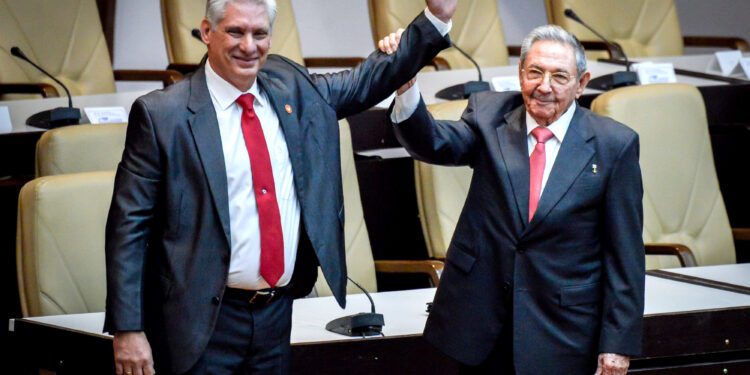 Newly elected Cuban President Miguel Diaz-Canel (L) reacts as former Cuban President Raul Castro raises his hand during the National Assembly in Havana, Cuba, April 19, 2018. REUTERS/Adalberto Roque/Pool via Reuters