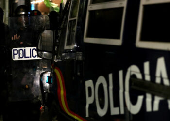 Policías de pie junto a un coche de policía mientras los manifestantes independentistas asisten a una protesta contra la acción policial frente a la sede de la Policía Nacional, en Barcelona, España, el 26 de octubre de 2019. REUTERS/Sergio Pérez