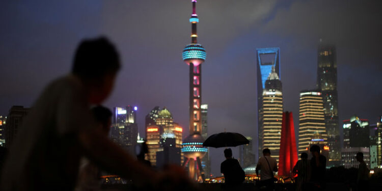 FOTO DE ARCHIVO: Grupo de personas en un puente frente al distrito financiero de Pudong en Shanghái, China, el 19 de julio de 2019. REUTERS/Canción Aliada