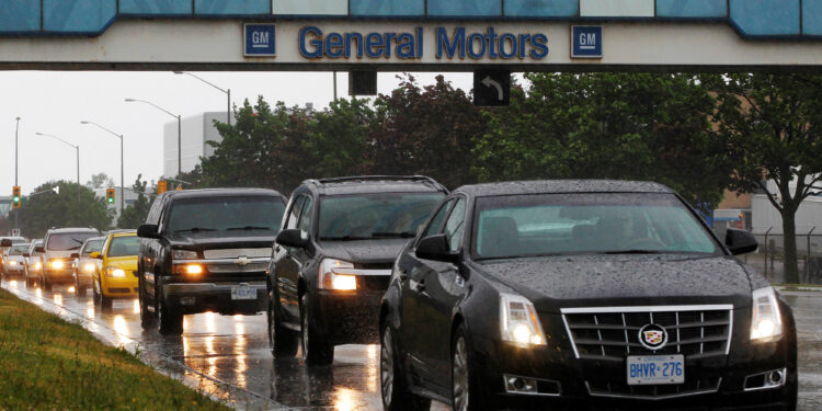 FILE PHOTO: A line up of cars is seen on a road after a shift change at the General Motors Car assembly plant in Oshawa, June 1, 2012.   REUTERS/Mark Blinch/File Photo