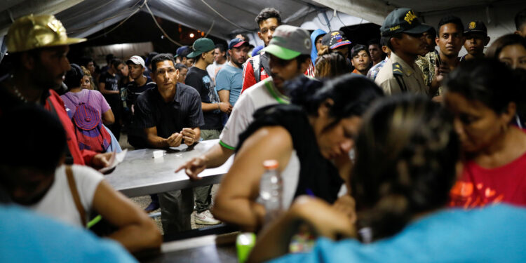 Migrantes venezolanos esperan en fila para vacunarse en el puesto fronterizo entre Perú y Ecuador en las afueras de Tumbes, Perú. Foto tomada el 14 de junio 2019. REUTERS/Carlos García Rawlins.