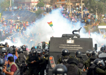 Bolivian riot police clash with supporters of Bolivia's ex-President Evo Morales during a protest against the interim government, in Sacaba, Chapare province, Cochabamba department on November 15, 2019. - Bolivia's interim president Jeanine Anez said Friday that exiled ex-president Evo Morales would have to "answer to justice" over election irregularities and government corruption if he returns. (Photo by STR / AFP)