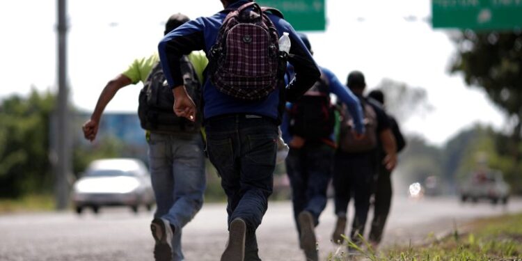 Men belonging to a caravan of migrants from El Salvador en route to the United States, run after they perceive the presence of police at the entrance of Tecun Uman, Guatemala, November 1, 2018. REUTERS/Ueslei Marcelino