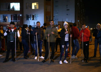 Residents hold sticks as they stand in front of their apartment block to guard their homes from possible looting after a curfew was enforced following renewed protests on the second day of a national strike, in Bogota, Colombia, November 22, 2019. REUTERS/Luisa Gonzalez