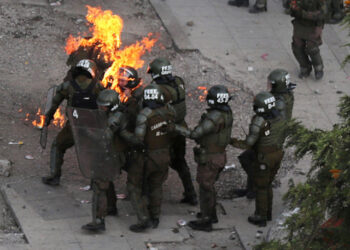 Riot police officers who are on fire are assisted by fellow officers during a protest against Chile's government in Santiago, Chile, November 4, 2019. REUTERS/Ivan Alvarado/File photo SEARCH "PICTURE RIOT" FOR THIS STORY. SEARCH "WIDER IMAGE" FOR ALL STORIES.