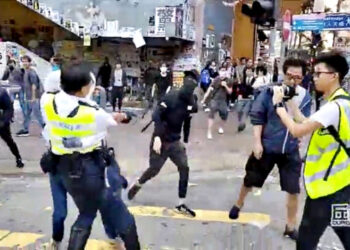 A still image from a social media video shows a police officer aiming his gun as a protester in Sai Wan Ho, Hong Kong, China November 11, 2019.   CUPID PRODUCER via REUTERS  ATTENTION EDITORS - THIS IMAGE HAS BEEN SUPPLIED BY A THIRD PARTY. MANDATORY CREDIT. NO RESALES. NO ARCHIVES.