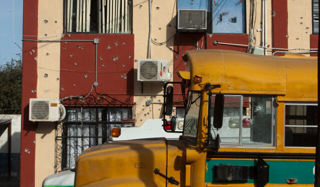 A shot school bus remains outside the Municipal Presidency in Villa Union, Coahuila state, Mexico, on December 2, 2019. - Mexican security forces were on Monday searching for the gunmen wich perpetrate the armed attack on the authorities of Villa Union over the weekend with a toll of 22 dead, including 16 of the alleged criminals. (Photo by Julio Cesar AGUILAR / AFP)