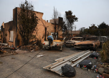 A house and vehicles gutted by bushfires are seen in the town of Lake Conjola in New South Wales on January 1, 2020. - A major operation to reach thousands of people stranded in fire-ravaged seaside towns was under way in Australia on January 1 after deadly bushfires ripped through popular tourist spots and rural areas leaving at least eight people dead. (Photo by PETER PARKS / AFP)