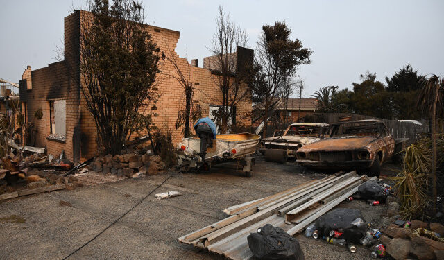 A house and vehicles gutted by bushfires are seen in the town of Lake Conjola in New South Wales on January 1, 2020. - A major operation to reach thousands of people stranded in fire-ravaged seaside towns was under way in Australia on January 1 after deadly bushfires ripped through popular tourist spots and rural areas leaving at least eight people dead. (Photo by PETER PARKS / AFP)