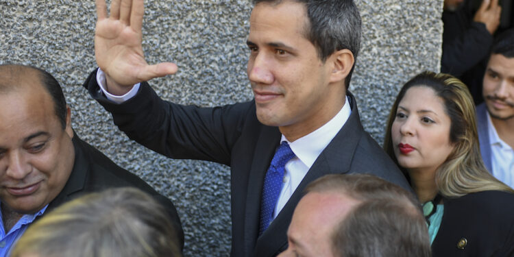 Venezuelan opposition leader and self-proclaimed acting president Juan Guaido waves while heading to the National Assembly, in Caracas, on January 7, 2020. - Opposition leader Juan Guaido and a rival lawmaker, Luis Parra -who both had claimed to be Venezuela's parliament speaker, following two separate votes and accusations of a "parliamentary coup- called for a parliamentary session today. (Photo by Yuri CORTEZ / AFP)