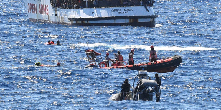 Varios inmigrantes nadan en el Mediterráneo tras saltar del barco español de rescate Open Arms frente a las costas de Lampedusa, Italia. 20 agosto 2019. REUTERS/Guglielmo Mangiapane