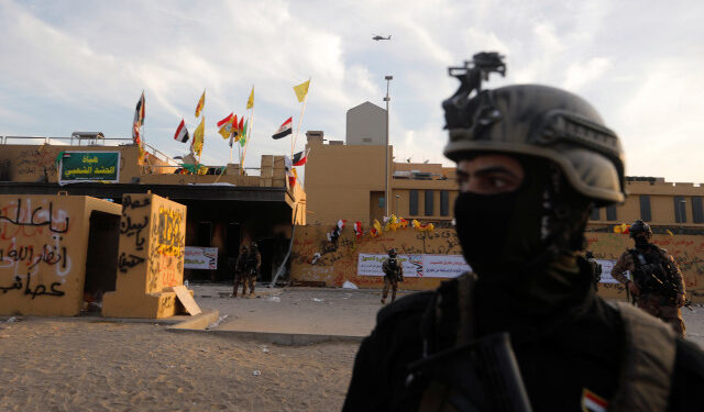 Members of Iraqi security forces are seen in front of U.S. Embassy during a protest to condemn air strikes on bases belonging to Hashd al-Shaabi (paramilitary forces), in Baghdad, Iraq January 1, 2020. REUTERS/Khalid al-Mousily