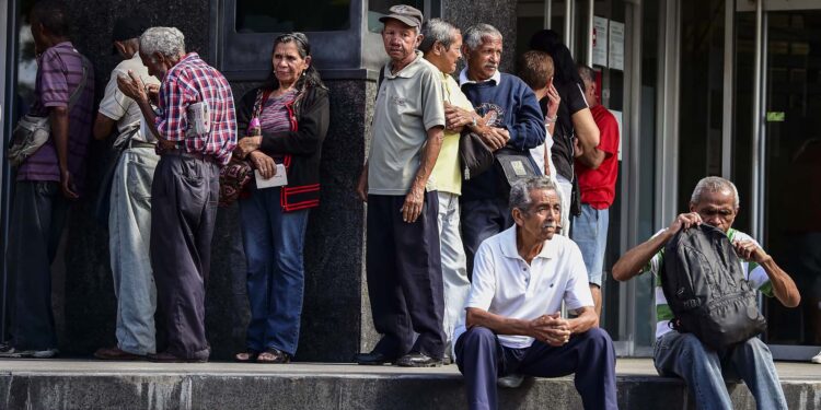 Elderly people wait for their pension monthly payment outside a bank in Caracas, on February 22, 2019. (Photo by RONALDO SCHEMIDT / AFP)