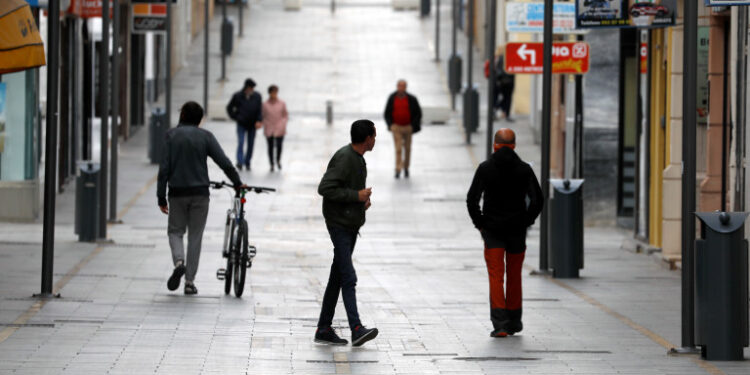 People walk in the empty La Bola street, under partial lockdown as part of a 15-day state of emergency to combat the coronavirus outbreak in downtown Ronda, southern Spain, March 15, 2020. REUTERS/Jon Nazca