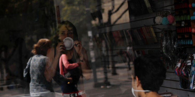 A woman wears a protective mask inside a shop in response to coronavirus (COVID-19) spread in Caracas, Venezuela March 13, 2020. REUTERS/Carlos Jasso