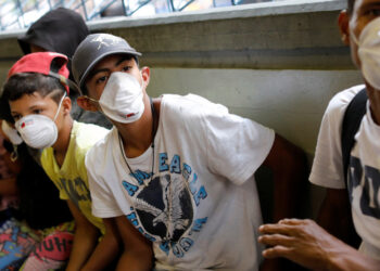 People outside a metro station wear face masks distributed by members of the Taiwan and Venezuela Parliamentary Friendship team, in response to the spreading coronavirus (COVID-19), in Caracas, Venezuela March 12, 2020. REUTERS/Carlos Jasso