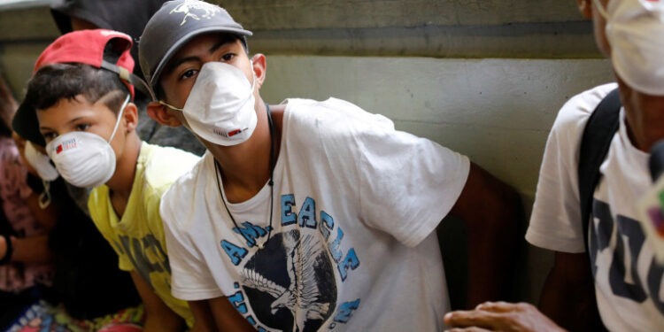 People outside a metro station wear face masks distributed by members of the Taiwan and Venezuela Parliamentary Friendship team, in response to the spreading coronavirus (COVID-19), in Caracas, Venezuela March 12, 2020. REUTERS/Carlos Jasso