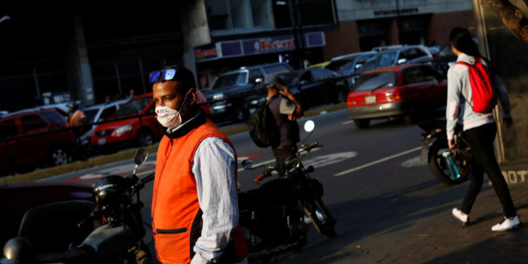 A man outside a metro station wears a face mask distributed by members of the Taiwan and Venezuela Parliamentary Friendship team, in response to the spreading coronavirus (COVID-19), in Caracas, Venezuela March 12, 2020. REUTERS/Carlos Jasso