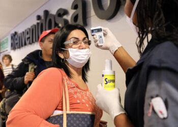 Funcionarios toman la temperatura de los ciudadanos que llegan al aeropuerto internacional El Dorado, el jueves 5 de marzo de 2020, en Bogotá (Colombia). El Ministerio de Salud de Colombia confirmó este viernes el primer caso de coronavirus en el país, una paciente que está internada en una clínica de Bogotá donde fue diagnosticada con el COVID-19. EFE/ Carlos Ortega