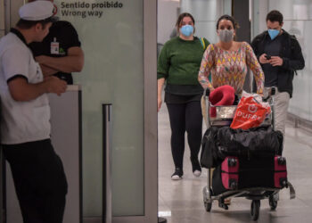 Passengers wearing masks as a precautionary measure to avoid contracting the new coronavirus, COVID-19, arrive on a flight from Italy at Guarulhos International Airport, in Guarulhos, Sao Paulo, Brazil on March 2, 2020. - The death toll from the new coronavirus epidemic surpassed 3,000 on Monday. The virus has now infected more than 89,000, spread to over 60 countries and threatens to cause a global economic slowdown -- after first emerging in China late last year. (Photo by Nelson ALMEIDA / AFP)