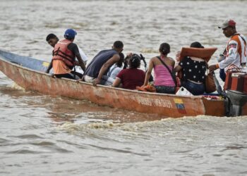 Venezuelans are transported in a canoe in the Arauca River in Arauca, Colombia, on border with Venezuela, on May 15, 2019. - Venezuelan migrants find anti-personnel mines, forced recruitment of armed groups, trafficking networks in Colombia. Vulnerable, the migrants are cannon fodder of all traffics. (Photo by Juan BARRETO / AFP)