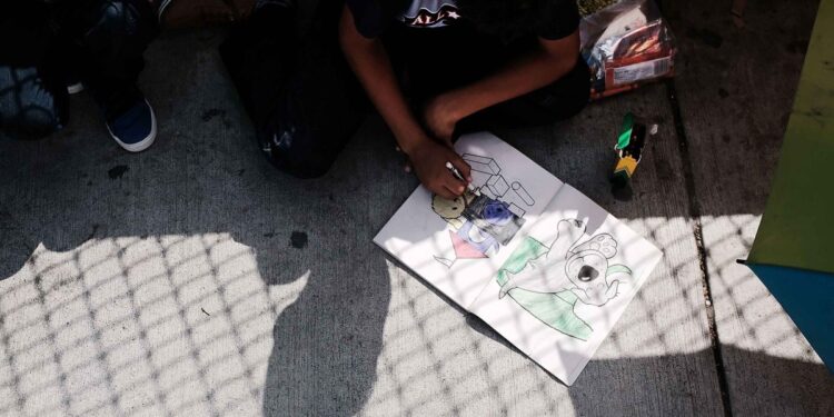 BROWNSVILLE, TX - JUNE 25:  A Honduran child works in a coloring book while waiting with his family along the border bridge after being denied entry from Mexico into the U.S. on June 25, 2018 in Brownsville, Texas. Immigration has once again been put in the spotlight as Democrats and Republicans spar over the detention of children and families seeking asylum at the border. Before President Donald Trump signed an executive order last week that halts the practice of separating families who are seeking asylum, more than 2,300 immigrant children had been separated from their parents in the zero-tolerance policy for border crossers.  (Photo by Spencer Platt/Getty Images)