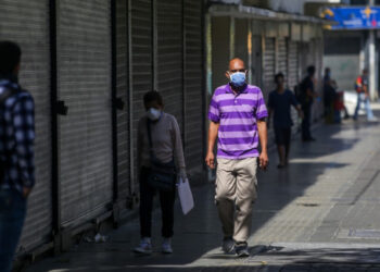 People wear face masks as a precautionary measure against the spread of the new coronavirus, COVID-19, in Caracas, on March 16, 2020. - Venezuelan President Nicolas Maduro ordered on Sunday a "collective quarantine" in seven states, including the capital Caracas, from Monday to stem the spread of the new coronavirus pandemic. (Photo by Cristian Hernandez / AFP)