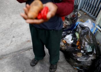 A man holds vegetables after he scavenges for food in a rubbish bin in Caracas, Venezuela February 27, 2019. Picture taken February 27, 2019. REUTERS/Carlos Jasso