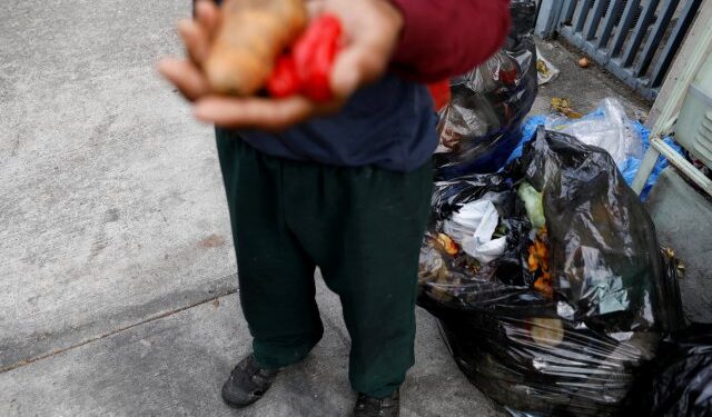 A man holds vegetables after he scavenges for food in a rubbish bin in Caracas, Venezuela February 27, 2019. Picture taken February 27, 2019. REUTERS/Carlos Jasso