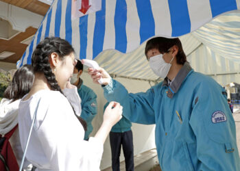 A visitor receives a temperature check as she enters the Toshimaen amusement park, which reopened after a three-week closure to prevent the spread of the coronavirus disease (COVID-19) in Tokyo, Japan March 21, 2020, in this photo taken by Kyodo.  Mandatory credit Kyodo/via REUTERS ATTENTION EDITORS - THIS IMAGE WAS PROVIDED BY A THIRD PARTY. MANDATORY CREDIT. JAPAN OUT.
