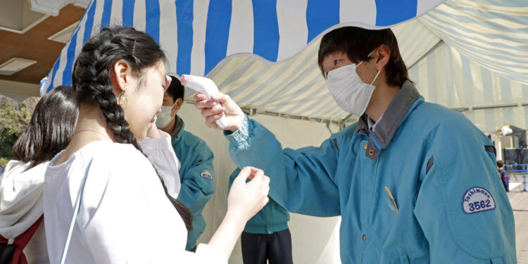 A visitor receives a temperature check as she enters the Toshimaen amusement park, which reopened after a three-week closure to prevent the spread of the coronavirus disease (COVID-19) in Tokyo, Japan March 21, 2020, in this photo taken by Kyodo.  Mandatory credit Kyodo/via REUTERS ATTENTION EDITORS - THIS IMAGE WAS PROVIDED BY A THIRD PARTY. MANDATORY CREDIT. JAPAN OUT.