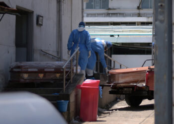 Health workers wearing protective gear load coffins outside of Teodoro Maldonado Carbo Hospital amid the spread of the coronavirus disease (COVID-19), in Guayaquil, Ecuador April 3, 2020. Picture taken April 3, 2020. REUTERS/Vicente Gaibor del Pino NO RESALES. NO ARCHIVES