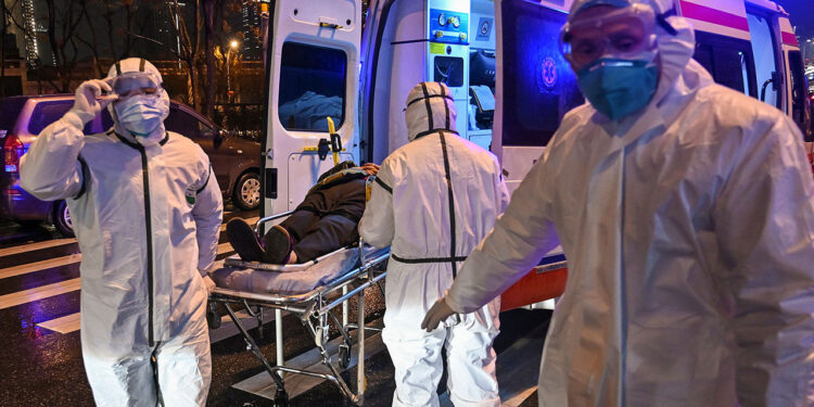 Medical staff members wearing protective clothing to help stop the spread of a deadly virus which began in the city, arrive with a patient at the Wuhan Red Cross Hospital in Wuhan on January 25, 2020. - The Chinese army deployed medical specialists on January 25 to the epicentre of a spiralling viral outbreak that has killed 41 people and spread around the world, as millions spent their normally festive Lunar New Year holiday under lockdown. (Photo by Hector RETAMAL / AFP) (Photo by HECTOR RETAMAL/AFP via Getty Images)