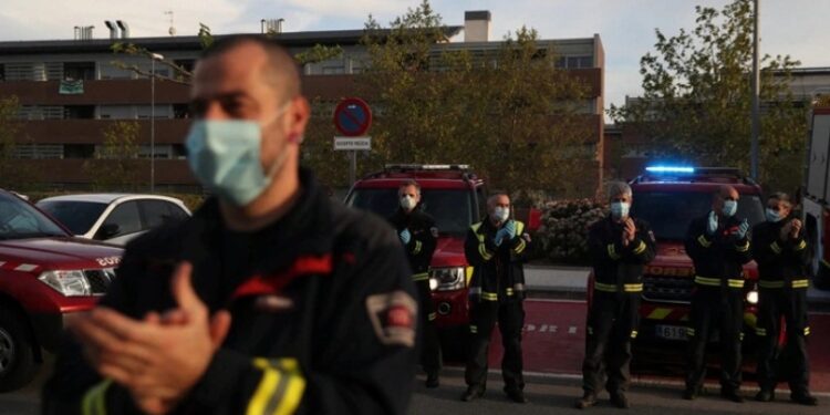 Bomberos aplauden al personal sanitario en el hospital Puerta de Hierro, en Madrid España. Foto Reuters.