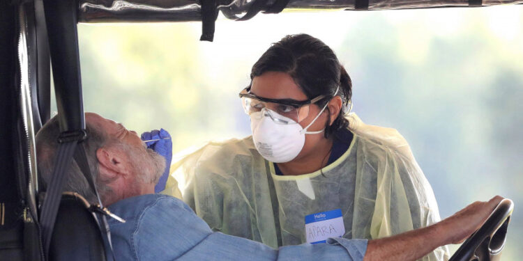 A resident of The Villages, Fla. gets tested for the coronavirus with a nasal swab at a drive-through site that accomodates golf carts, at The Villages Polo Club, Monday, March 23, 2020. The testing site is being operated by UF Health, with University of Florida medical students performing the tests. (Joe Burbank/Orlando Sentinel/Tribune News Service via Getty Images)