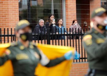 Ciudadanos bajo cuarentena salen este viernes a los balcones de sus hogares mientras la Policía realiza un espectáculo de música tropical colombiana, en el barrio Pontevedra de Bogotá (Colombia). Un grupo de policías colombianos llega cada día con bailes y cantos a un barrio de Bogotá para entretener y animar a las personas confinadas en sus hogares por la cuarentena que busca mitigar la propagación del coronavirus. La jornada de este viernes se hizo en un camión que fue adaptado como tarima y en la que los uniformados desplegaron frente a un conjunto residencial una presentación musical con ritmos tropicales colombianos. EFE/ Mauricio Dueñas Castañeda