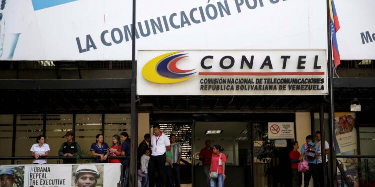 FILE PHOTO: A woman walks out from the building of the National Commission of Telecommunications (CONATEL), in Caracas, Venezuela February 16, 2017. REUTERS/Marco Bello/File Photo