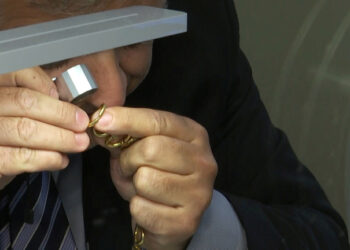 Foto de un empleado de una casa de empeño examinando piezas de oro que van a ser vendida, en Roma. 
May 13, 2020. REUTERS/Cristiano Corvino