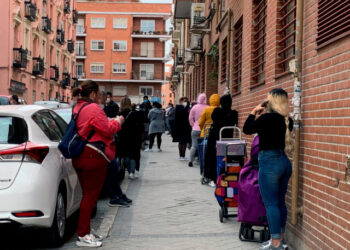 GRAF9028. MADRID, 21/05/2020.-  Vista de la fila de clientes que aguardan su turno para entrar al economato de Cáritas en el distrito madrileño de Tetuán, donde familias y personas necesitadas pueden comprar alimentos y otros productos de primera necesidad a precio subvencionado. La crisis causada por la pandemia ha golpeado duro a las comunidades de latinoamericanos en España, con frecuencia en el nivel más frágil de la escala social, y ahora muchos de ellos se ven abocados a la pobreza y a la ayuda para sobrevivir. A menudo atrapados en empleos temporales o informales, los latinos se han visto afectados de forma desmedida por el huracán que se ha llevado por delante, hasta ahora, casi 950.000 empleos. EFE/Rafael Cañas