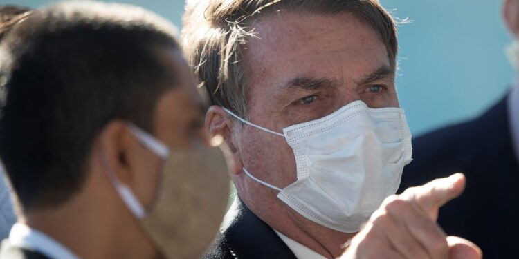 El presidente de Brasil, Jair Bolsonaro (d), sale este lunes, del Palacio do Alvorada, sede de la Presidencia, en Brasilia. EFE/Joedson Alves