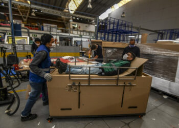 Workers assemble cardboard stretchers for clinics at a factory in Bogota on May 7, 2020, amid the new coronavirus pandemic. - Latin America and the Caribbean on Thursday exceeded 300,000 cases of the new coronavirus, which has caused the death of 16,293 people in the region, according to an AFP balance sheet prepared with official data. (Photo by Juan BARRETO / AFP)