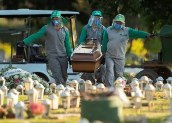 Trabajadores del cementerio Campo de Esperanza entierran a una víctima de covid-19 este jueves, en Brasilia (Brasil). EFE/Joédson Alves