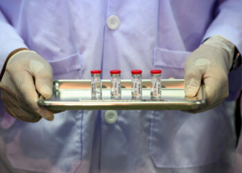 This picture taken on May 23, 2020 shows a laboratory technician holding a tray with doses of a COVID-19 novel coronavirus vaccine candidate ready for trial on monkeys at the National Primate Research Center of Thailand at Chulalongkorn University in Saraburi. - After conclusive results on mice, Thai scientists from the centre have begun testing a COVID-19 novel coronavirus vaccine candidate on monkeys, the phase before human trials. (Photo by Mladen ANTONOV / AFP)