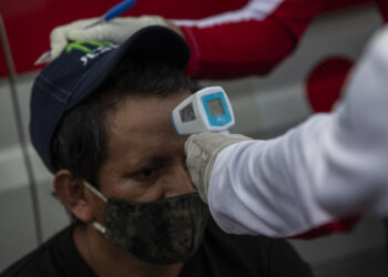 International Red Cross workers check truck drivers pressure and temperature during a blockade at Penas Blancas border between Nicaragua and Costa Rica, in Rivas, Nicaragua, on May 28, 2020. - Thousands of Nicaraguan truckers blocked the country's southern border on Wednesday, in retaliation for the sanitary restrictions imposed by Costa Rica on cargo transportation to contain the spread of the new coronavirus COVID-19. (Photo by Inti OCON / AFP)