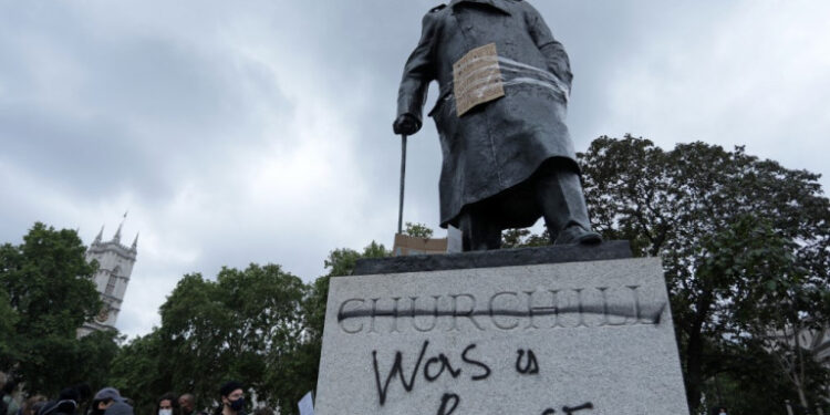 The statue of former British prime minister Winston Churchill is seen defaced, with the words (Churchill) "was a racist" written on it's base in Parliament Square, central London after a demonstration outside the US Embassy, on June 7, 2020, organised to show solidarity with the Black Lives Matter movement in the wake of the killing of George Floyd, an unarmed black man who died after a police officer knelt on his neck in Minneapolis. - Taking a knee, banging drums and ignoring social distancing measures, outraged protesters from Sydney to London on Saturday kicked off a weekend of global rallies against racism and police brutality. (Photo by ISABEL INFANTES / AFP)