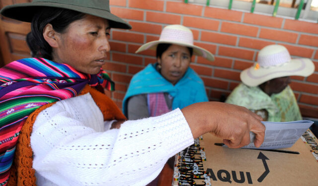 A Bolivian woman dressed in typical Andean attire casts her vote at a voting station in the village of Laja, in the highland Andean plateau, over 4,000 meters above sea level on October 12, 2014. More than six million Bolivians will elect their president for the next five years in an electoral process where voting is compulsory. AFP PHOTO/JORGE BERNAL