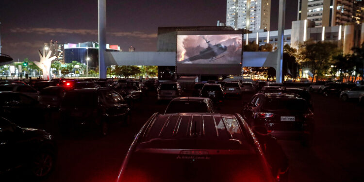 AME7373. SAO PAULO (BRASIL), 17/06/2020.- Decenas de personas a bordo de sus vehículos miran una película en un autocine este miércoles, en Sao Paulo (Brasil). En un espacio habilitado para unos 100 vehículos en el Memorial de América Latina, los habitantes de Sao Paulo podrán disfrutar del séptimo arte mientras los cines en teatros cerrados recuperan su normalidad debido a la pandemia de coronavirus en curso en el país. EFE/ Sebastião Moreira